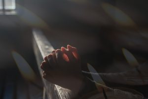 A person praying with an open Bible, trusting God in challenges.