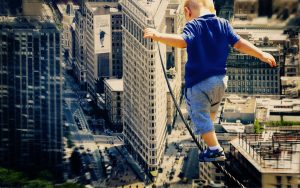 Have Faith - one step at a time. A young child walking on a high-wire.