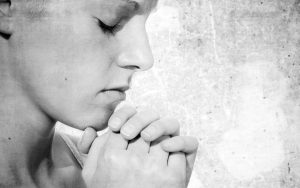 Pray about everything - a lady with eyes closed and hands in prayer.